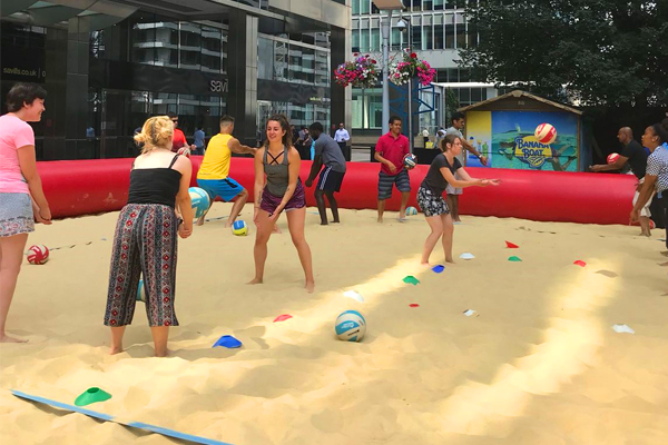 Group of young people learning beach volleyball